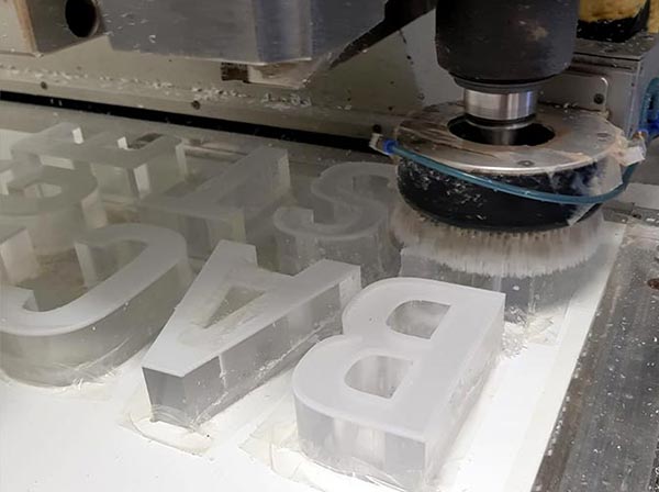 Acrylglas-Buchstaben werden mit der Maschine abgeschliffen