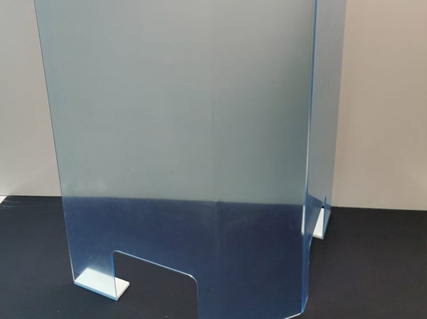 Plexiglas-Aufsteller mit blauer Schutzfolie auf einem Tisch