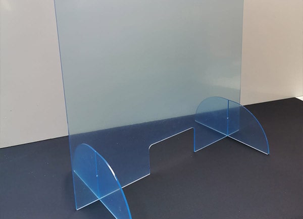 Mobiler Plexiglas-Aufsteller mit blauer Schutzfolie auf einem Tisch