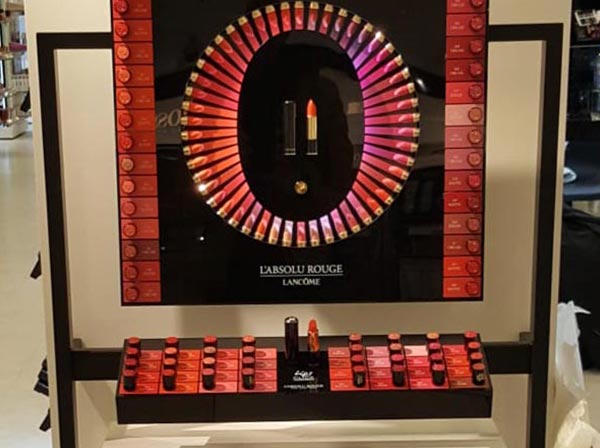 Produktdisplay für Lippenstifte von Lancóme mit Farbübersicht in einem Geschäft