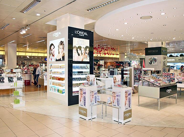 Ladeneinrichtung eines Geschäfts für Kosmetikartikeln mit Möbeln und Produktdisplays aus Acrylglas mit Bild und Schriftzug von L`Oréal