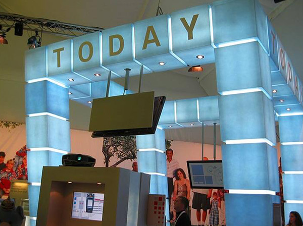 Messestand aus hellblauen Acrylglassäulen mit Beleuchtung, Beschriftung „today“ und montierten Bildschirmen