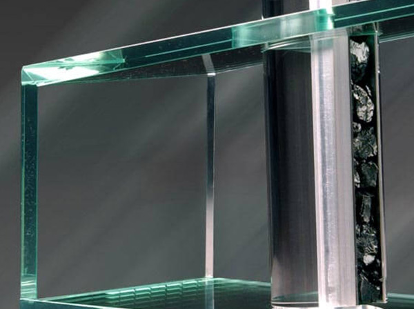Nahaufnahme eines grünlich-transparenten Plexiglastisches mit modernem Dekoelement